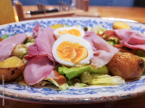 Photography Fresh salad topped with ham and hard-boiled egg
