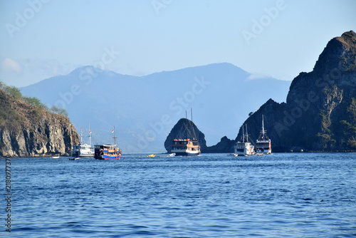 A Phinisi boat carrying tourists amidst the beautiful, rugged hills of the Komodo National Park area, Labuan Bajo, Indonesia