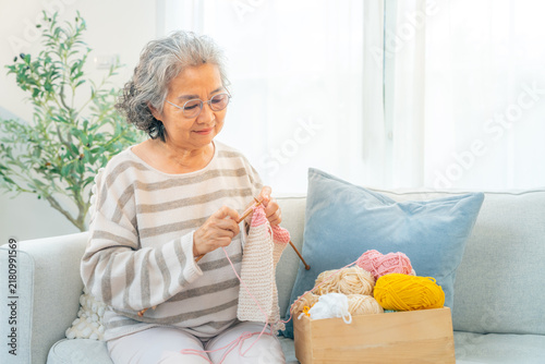 Konstfotografi Asian senior woman knitting handmade wool clothing at home, enjoy creative hobby