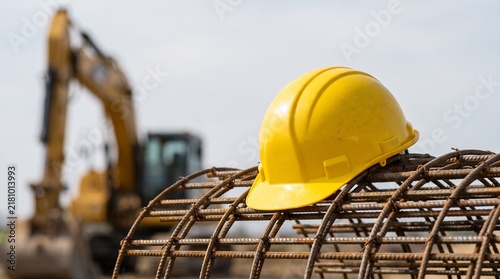 Yellow Hard Hat Resting On Steel Rebar Cage At Construction Site