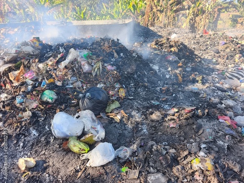 Canvastavla A smoking pile of burning garbage and plastic waste dumped outdoors on dirt, highlighting environmental pollution, ecological crisis, climate change, and waste management issues