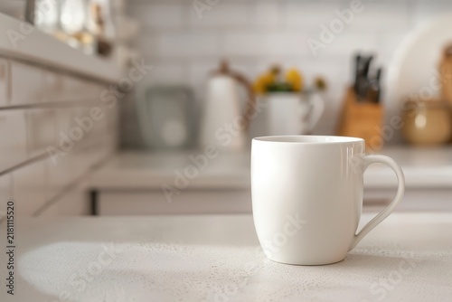 White ceramic coffee mug sitting on a bright kitchen countertop surface