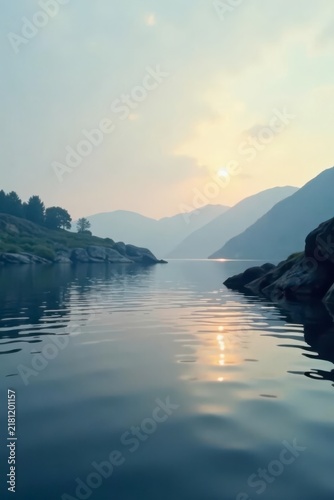 Serene Sunset Over Calm Water Surrounded by Majestic Mountains and Lush Green Hills