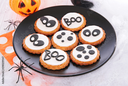 Halloween Decorated Cookies with Boo Text and Ghost Eyes Served on Black Plate