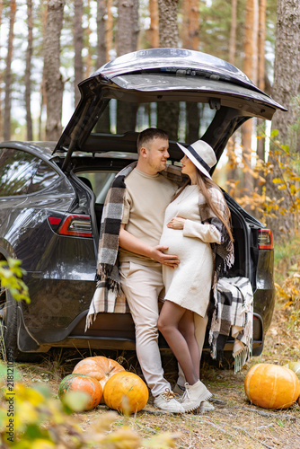 Bild auf Leinwand A loving couple expecting a baby enjoys a beautiful fall day in the woods, surro