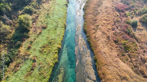 sandbar. Aerial view of a river split by a sandbar, creating two streams through green landscape. travel magazines, destination branding, designed for outdoor magazines and nature guides.