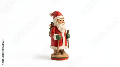 Hand carved wooden santa claus figurine holding ski poles with a gift sack on his back, isolated on white background