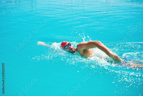 Obraz na plátne Fitness, man and swimming in pool for exercise, workout and aquatic practice for body wellness