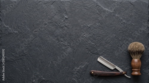 Canvas Print Straight razor and shaving brush on a dark textured stone background