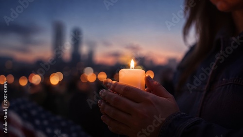 Memorial candle held against New York city lights