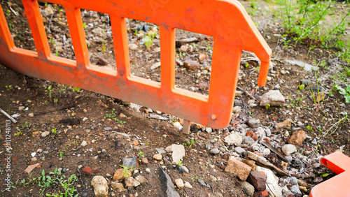 Fotografía Bright orange temporary safety barrier marking a construction area with exposed
