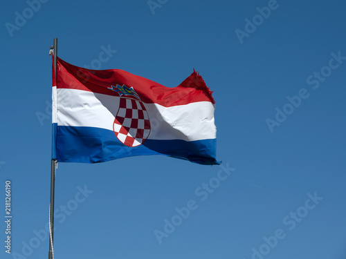 Foto Croatia flag  on flag pole flying isolated against blue sky