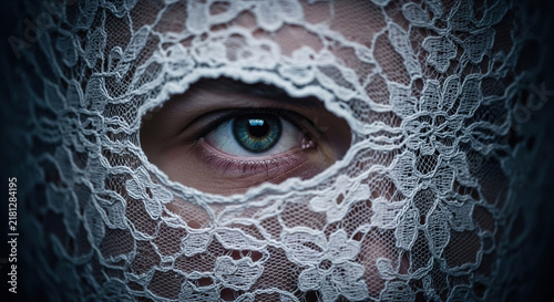 Woman's eye framed by intricate white lace veil