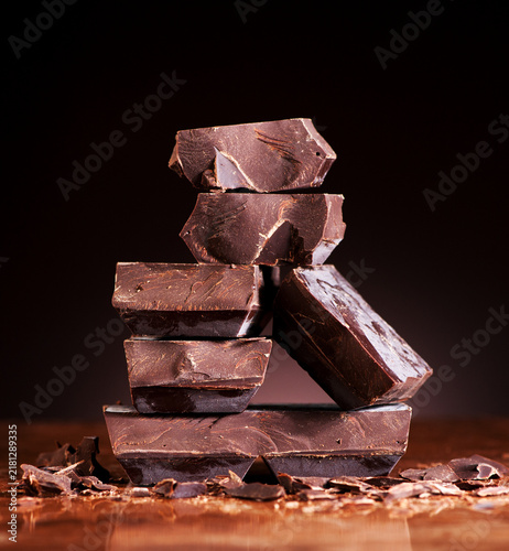 Foto Chopped chocolate chunks stacked on a dark marble background