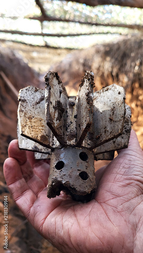 parts mortar mine in hand of a soldier. shank in hand, mortar mine tail. exploding shell. in the trench after the battle. ammunition shank. war. conflict. Russian-Ukrainian war in Donbass