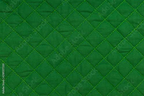 Fotografie Green quilted fabric texture with diamond stitching