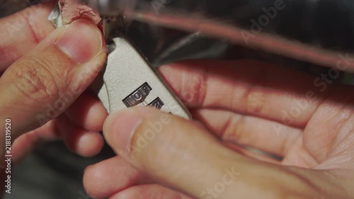 Close Up View of Hands Attempting to Brute Force a Combination Lock Padlock Number Dial