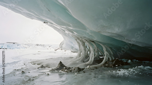 Ice cave formation with hanging icicles in glacial landscape