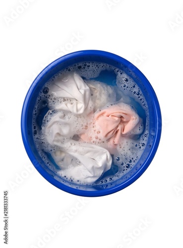 Plakat White laundry soaking in a blue plastic basin with soap bubbles