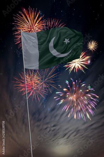Waving National flag of Pakistan and holiday fireworks in night sky