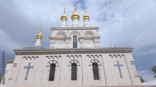 Circular exterior view of the Russian Orthodox Church in Geneva, Switzerland, showcasing its distinctive golden domes, ornate architecture, and historic facade.
