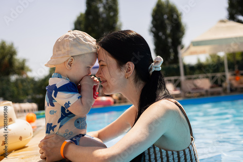 Obraz na plátně Mother and baby bonding by the pool on a sunny summer day