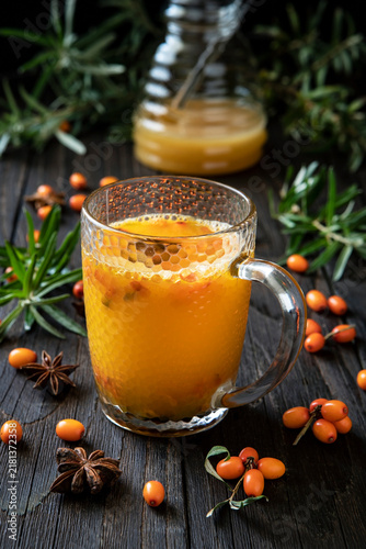 Glass cup of sea buckthorn tea on  dark background