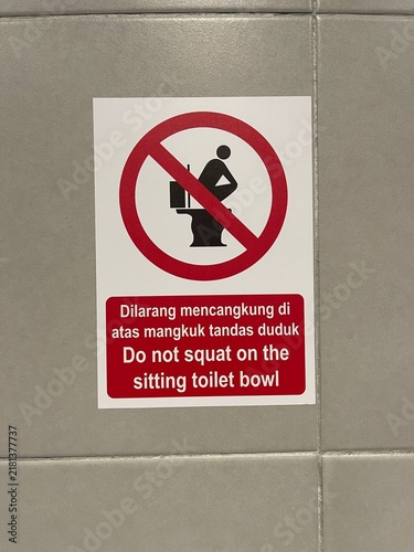 Cuadro en lienzo Bilingual prohibition sign warning against squatting on seated toilet bowl in public restroom