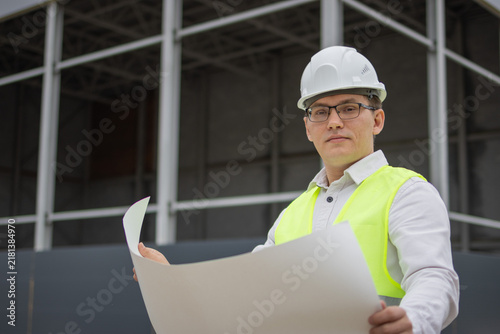 reflective vest. male engineer. building plan. paper drawing. High quality photo