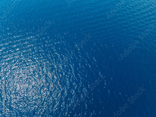 Aerial view of calm ocean water with sunlight reflections