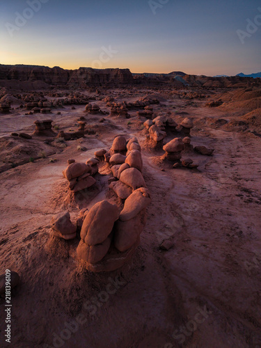 Aerial view of unique sandstone hoodoos and rock formations in Goblin Valley State Park at sunset with warm light casting long shadows in Green River, Utah, United States.