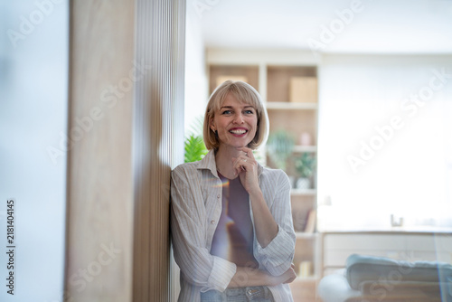 Konstfotografi Happy blonde woman thinking with confidence at home