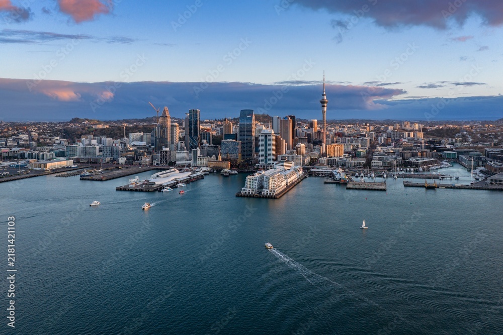 Obraz premium Scenic aerial view of the Auckland CBD skyline and Waitemata Harbour with boats cruising at sunset in Auckland, New Zealand.