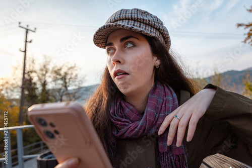 Foto Portrait of young woman reacting with visible disdain while checking smartphone screen