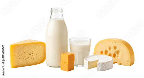 Fresh dairy products including a bottle of milk, glass of milk, various cheeses, and cheese cubes arranged on a surface.