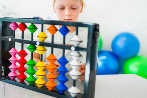 Konstfotografi Young boy visualizing and practicing mental arithmetic with a colorful abacus, developing concentration, calculation and cognitive skills