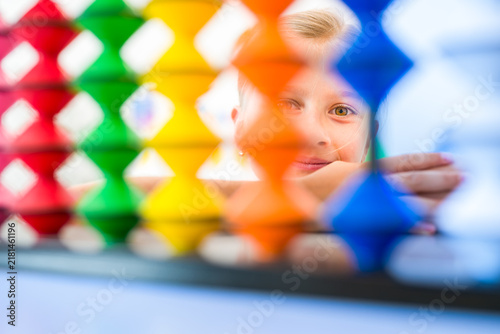 Bild auf Leinwand Young girl visualizing and practicing mental arithmetic with a colorful abacus, developing concentration, calculation and cognitive skills