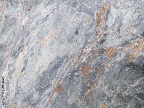 Fotografía Raw stone background with smooth-yet-rough texture, cool gray base with warm brown and rust-colored veins