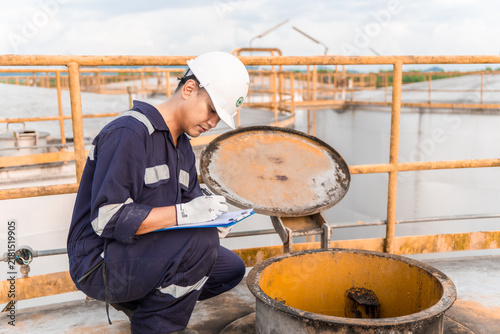 Petrochemical Engineers checking reports for technical inspections in oil refinery. Technicians working on checklist in the oil storage tank area. Factory and industry manufacturing. Oil tank.