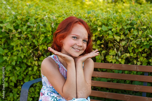A portrait of a teenage girl, smiling and enjoying a sunny summer day.