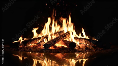 A realistic fire burning in an otherwise completely dark environment, with a subtle reflective surface beneath the flames. The warm orange and yellow light creates a soft shimmering reflection below t