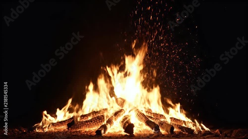 A cinematic ultra-realistic fire burning intensely in complete darkness. The entire background is deep pure black with no visible environment, creating a dramatic high-contrast atmosphere. Large natur