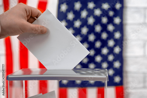 Foto Voter casting a voting ballot into a transparent ballot box with the US flag