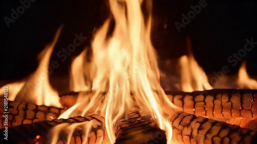 Extreme close-up macro view of beautiful realistic flames moving slowly in complete darkness. The camera focuses on intricate flame patterns, showing thin tongues of fire twisting around each other an