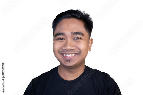 Young man smiles warmly against clean white background. He wears simple black top, looks directly at viewer. Friendly expression conveys approachability and positivity