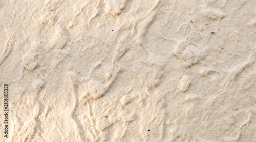 Textured handmade beige paper with uneven fibers creates a rustic and natural organic surface pattern perfect for artistic design backgrounds