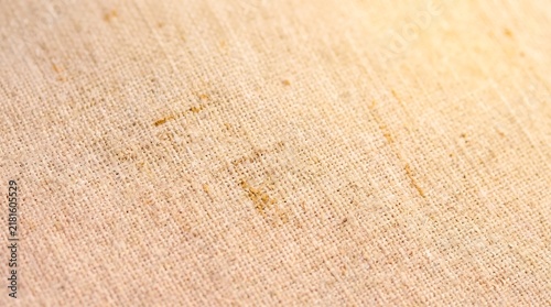 Textured beige burlap fabric surface featuring a close up macro perspective with soft golden light casting gentle warm natural shadows