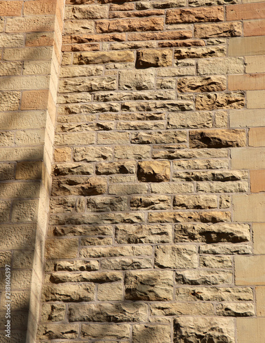 Foto Chiseled sandstone masonry wall texture with warm natural sunlight and shadow