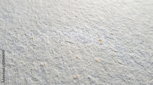 Macro view of white textured recycled paper surface showing natural fibers and uneven grain patterns in soft natural bright lighting