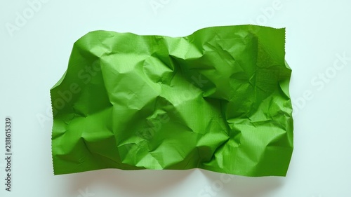 A Crumpled Green Piece of Paper with Wrinkles and Folds Against a Plain White Background